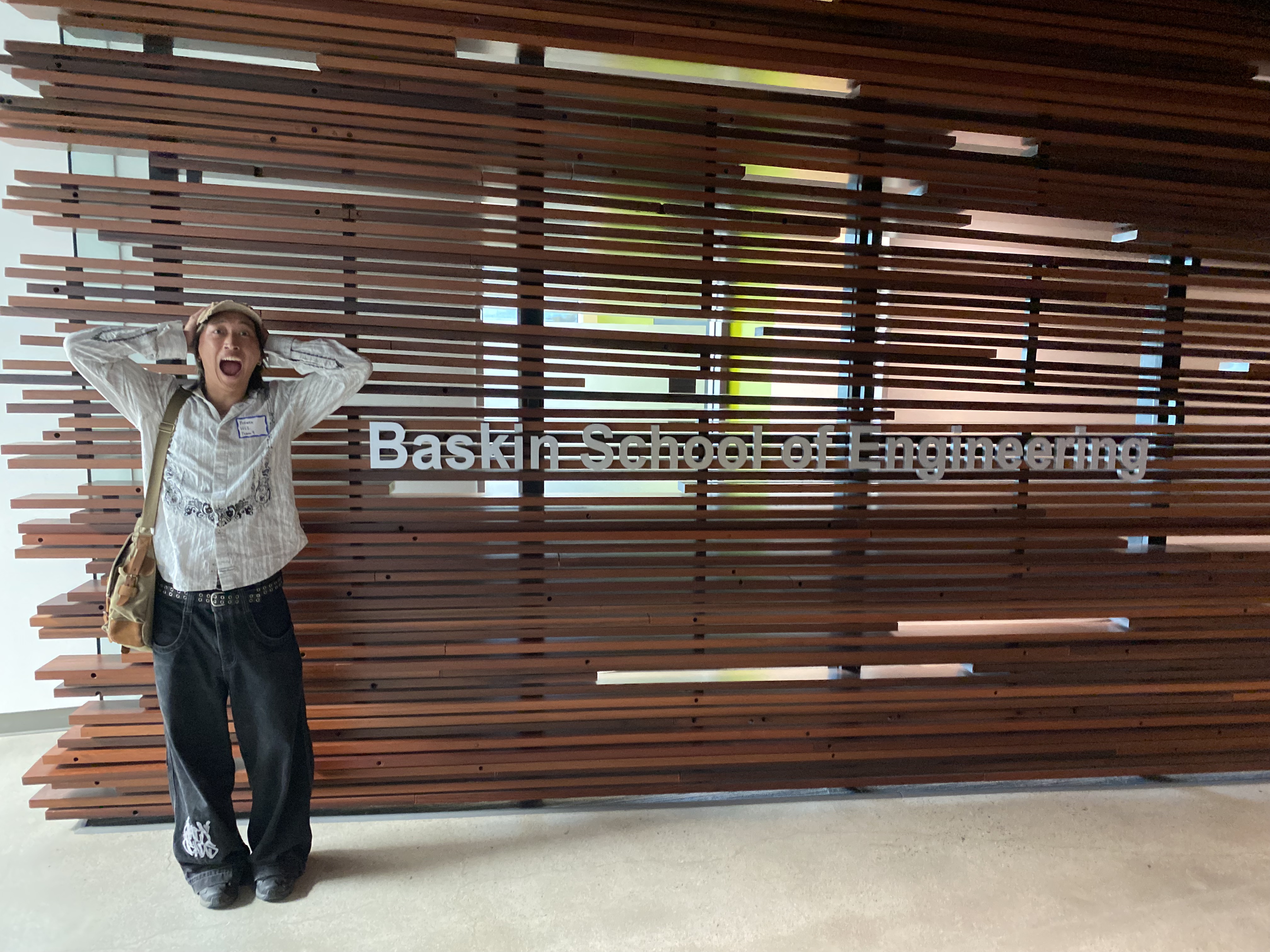 Kaiwen standing in front of the Baskin School of Engineering sign.